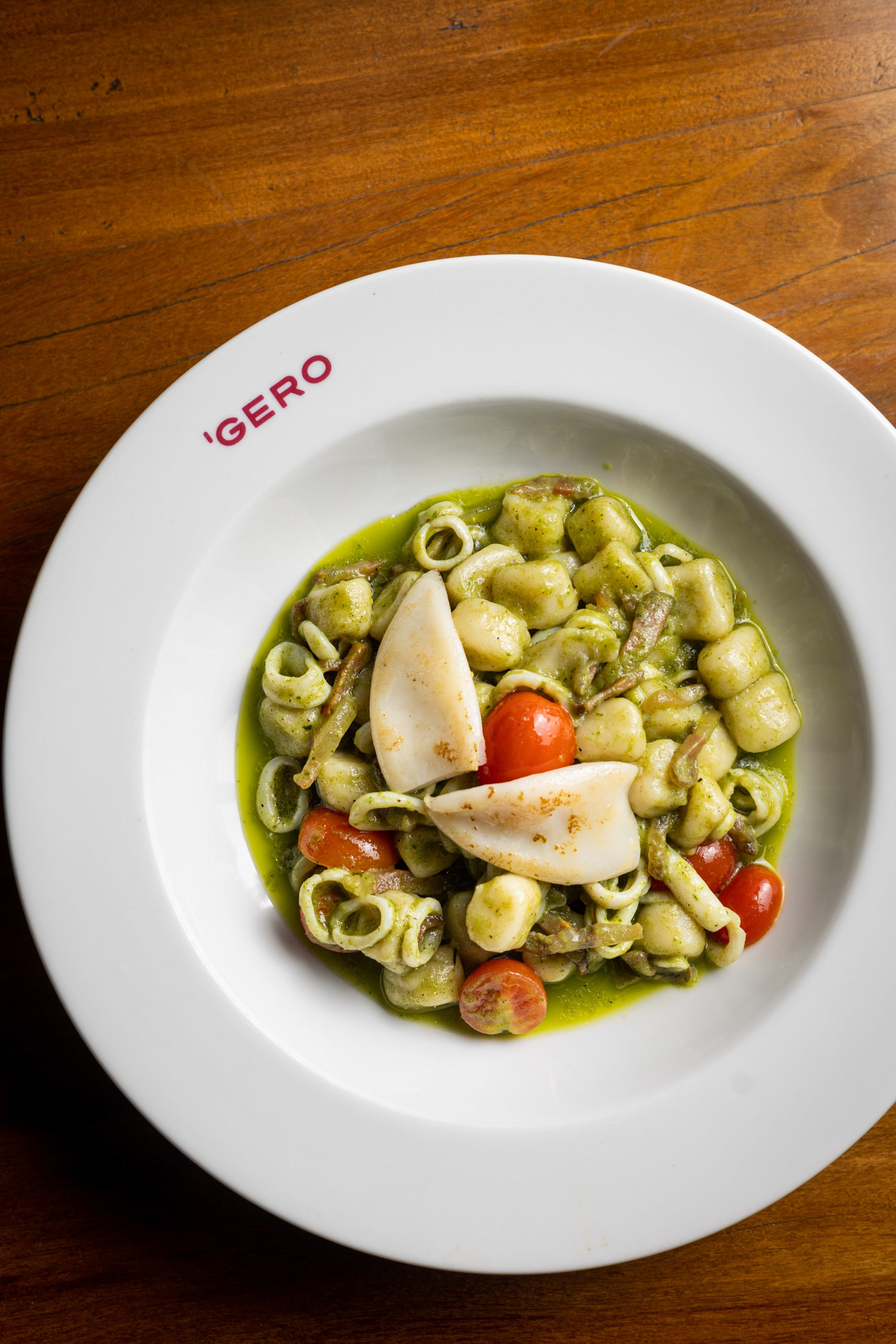 Gnocchi di patate al pesto di basilico con calamari e pancetta